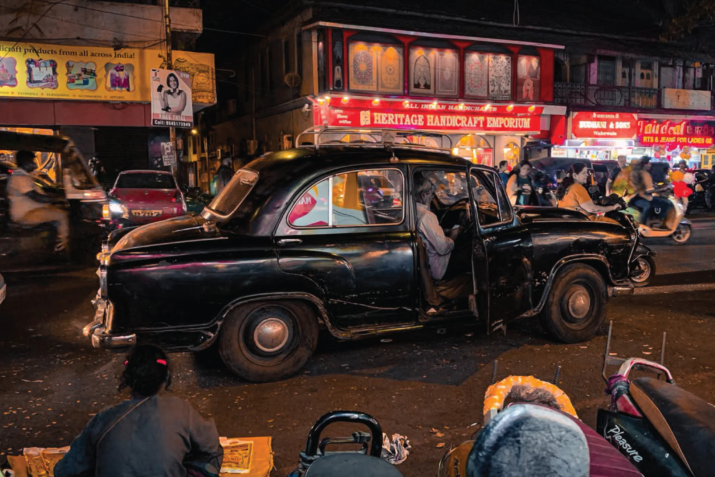 Street photograph of an Ambassador taxi at night